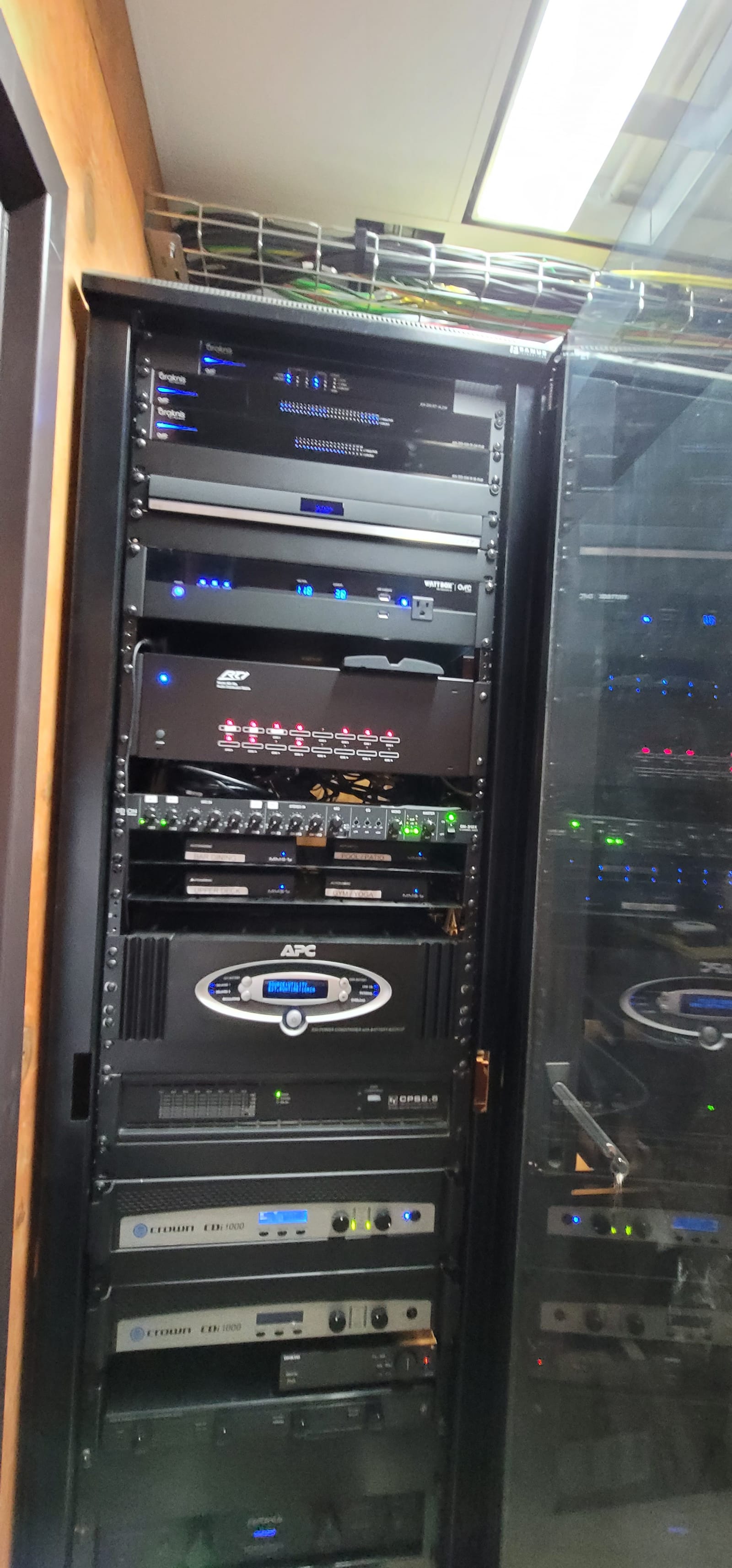Detail view of country club AV equipment rack with amplifiers, processors, and managed network gear