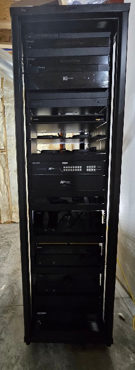 Custom-built whole-home AV equipment rack by Noble A-V, rack-mounted processors, amplifiers, and managed network gear neatly dressed
